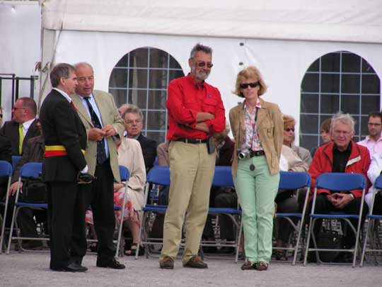 De uitnodigden personen komen aan en nemen plaats op het podium.