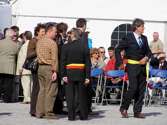 De uitnodigden personen komen aan en nemen plaats op het podium.